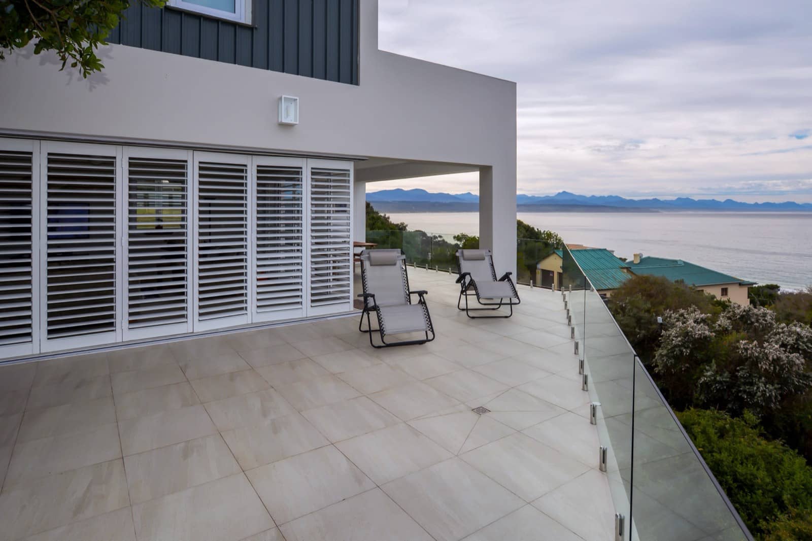 White aluminium security shutters enclosing a seafront terrace