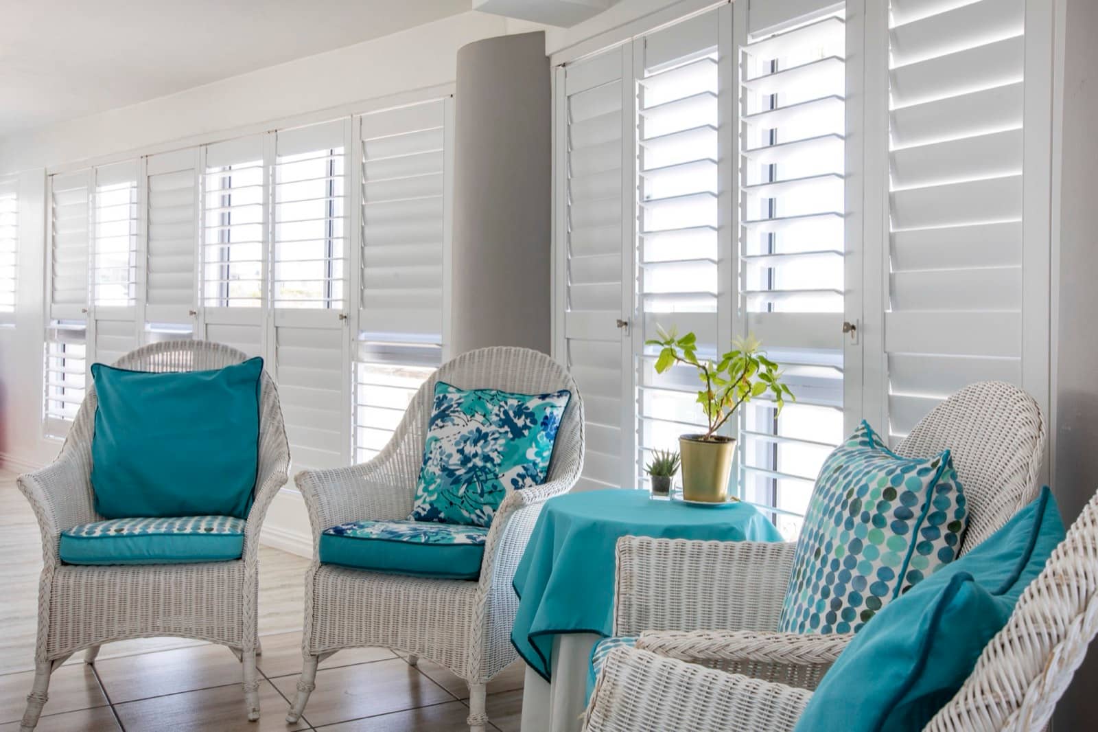 White aluminium shutters with tilted blades in a lounge