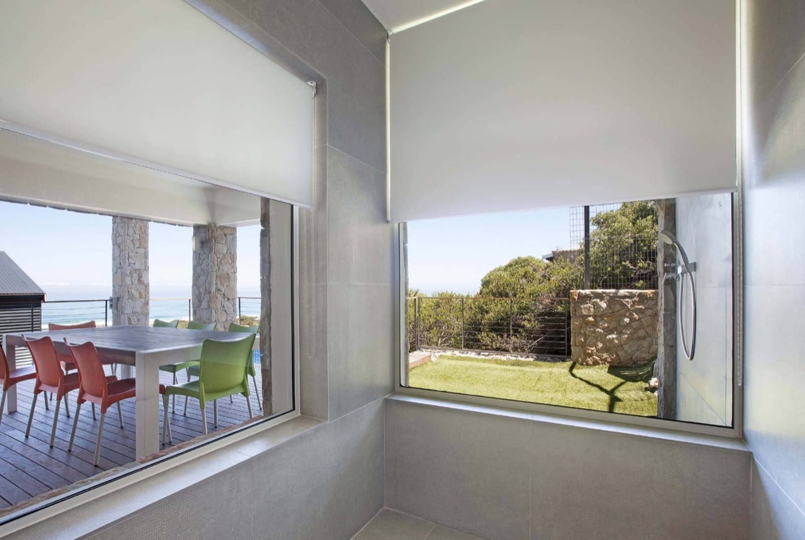 White blockout roller blinds lowered over large corner windows