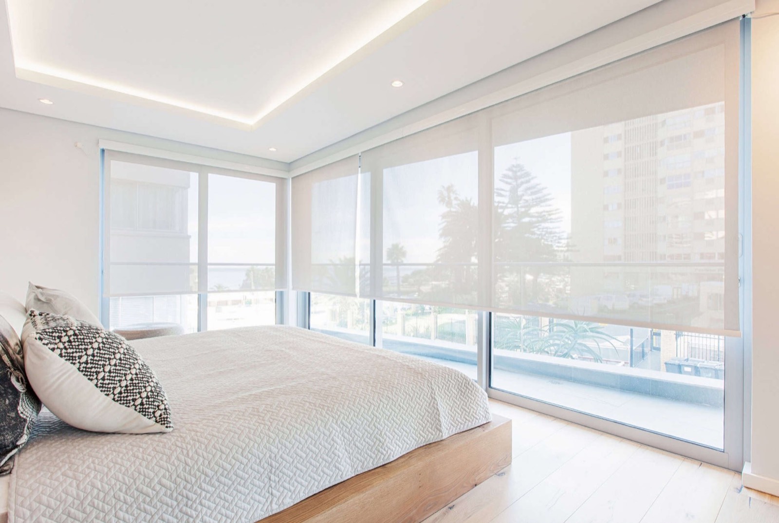Light-filtering roller blinds glowing softly over a living room window