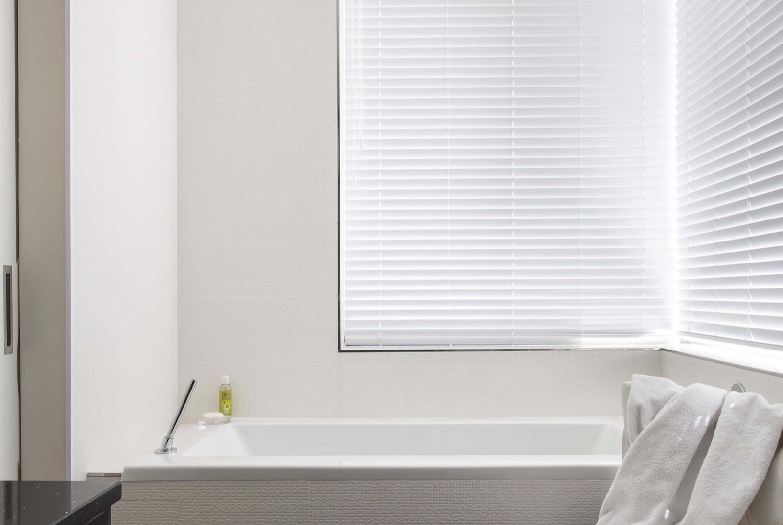 Wide 50mm white venetian slats over a bathroom window