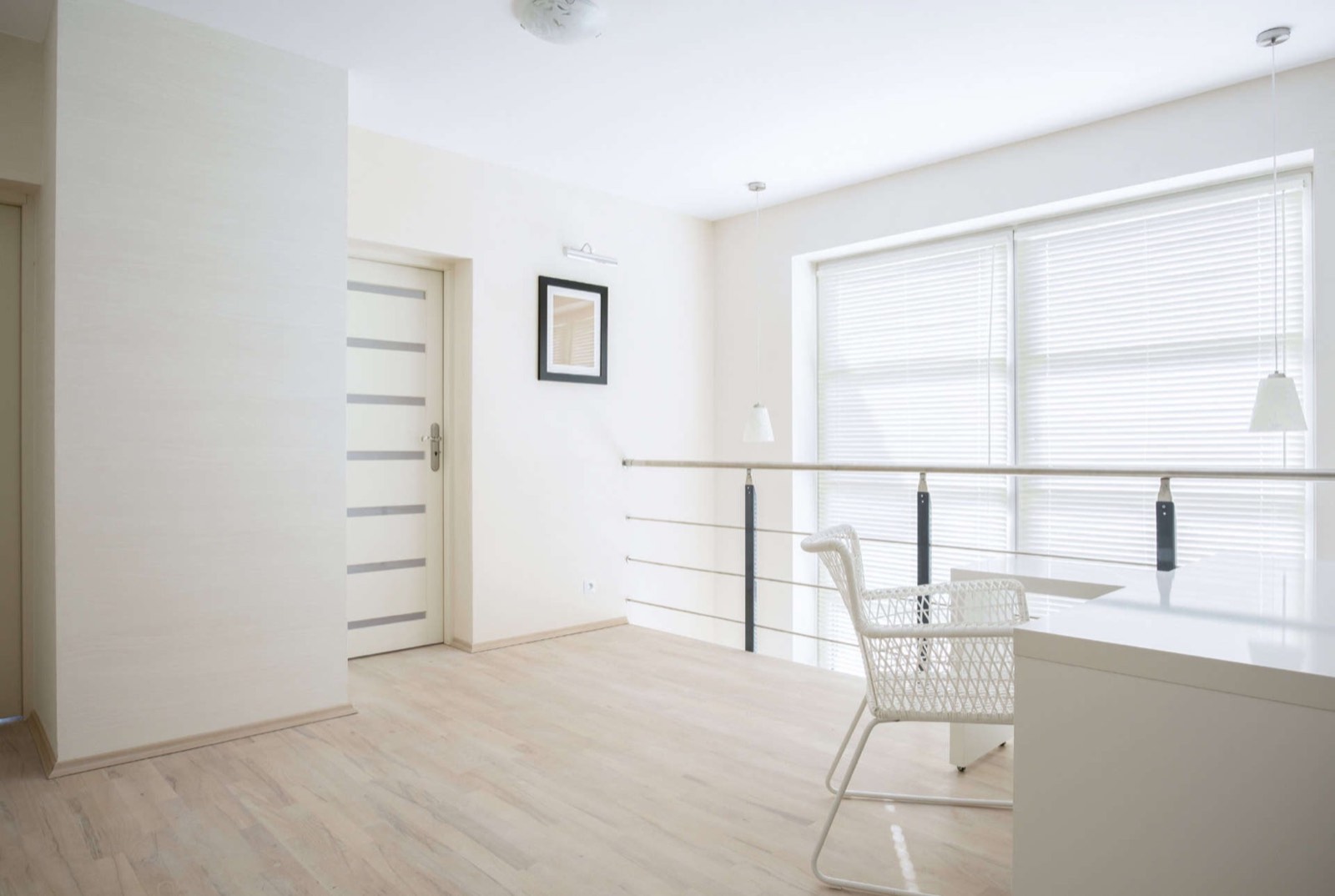 White aluminium venetian blinds on a bright landing window