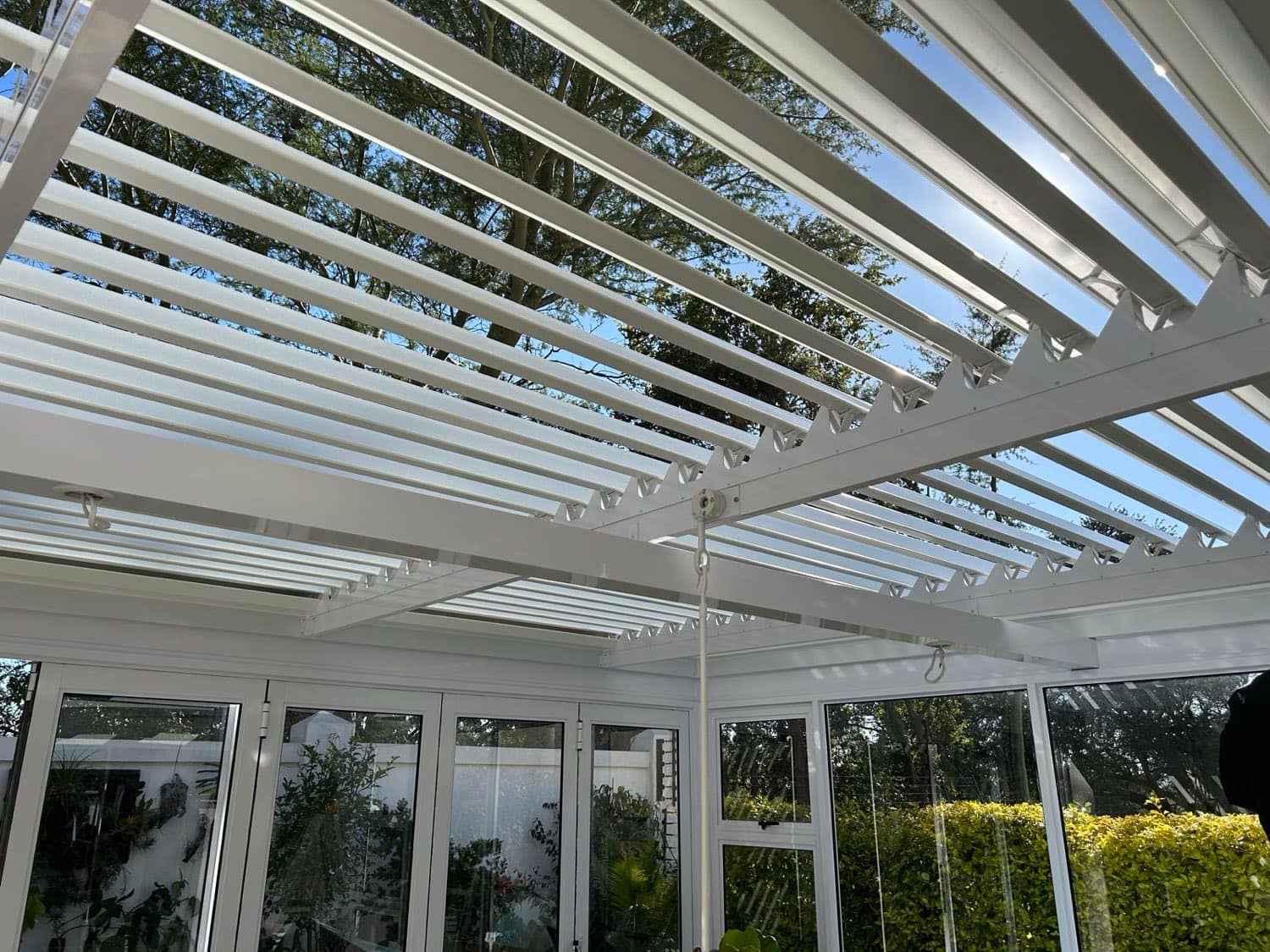 White louvre awning blades open to the sky over a Gauteng patio