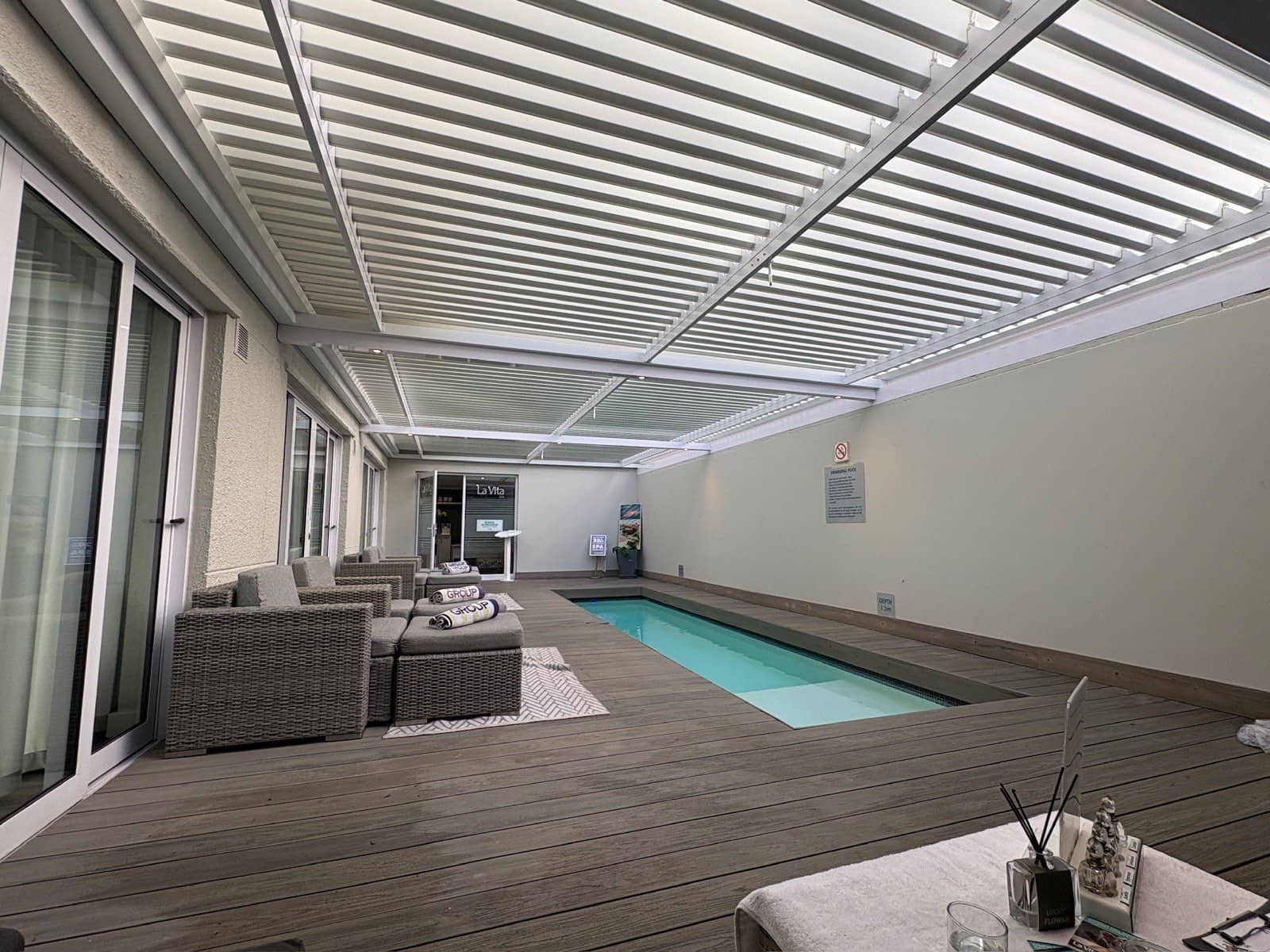 White aluminium louvre awning over a Sea Point pool courtyard
