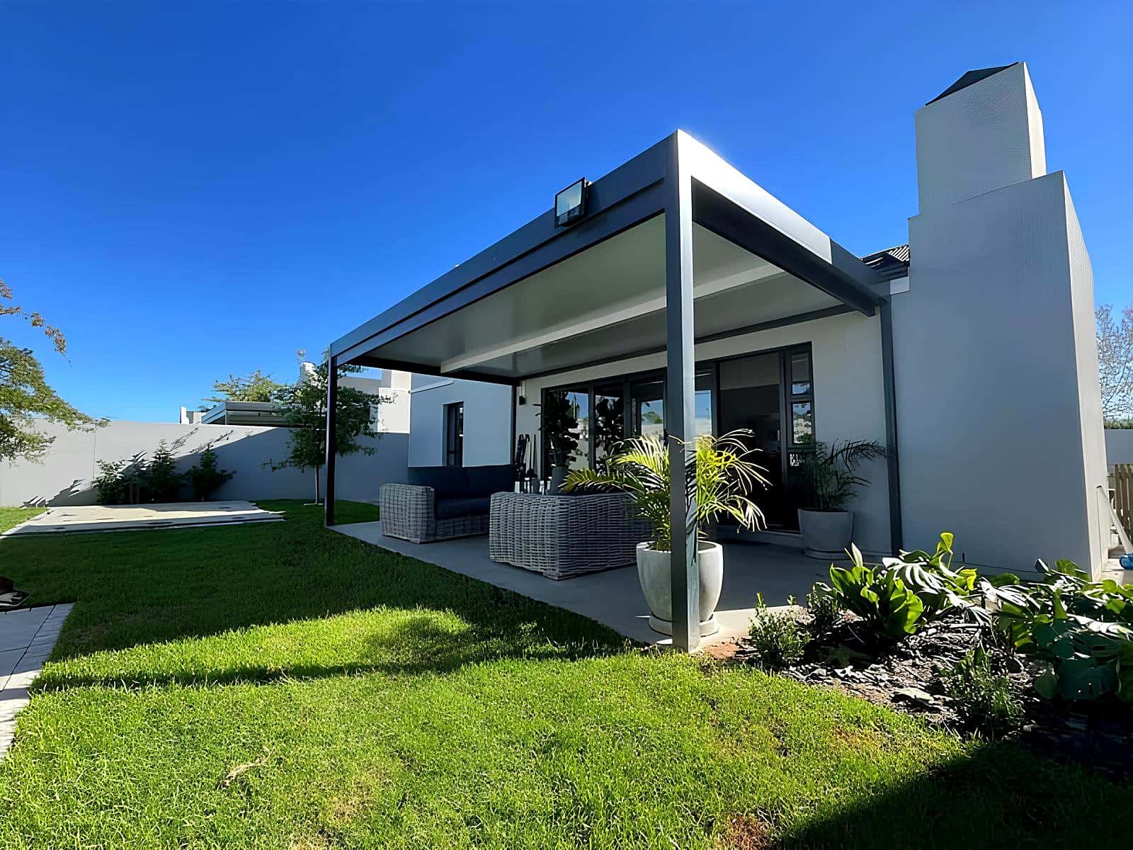 Flat charcoal and white aluminium patio cover on a modern estate home