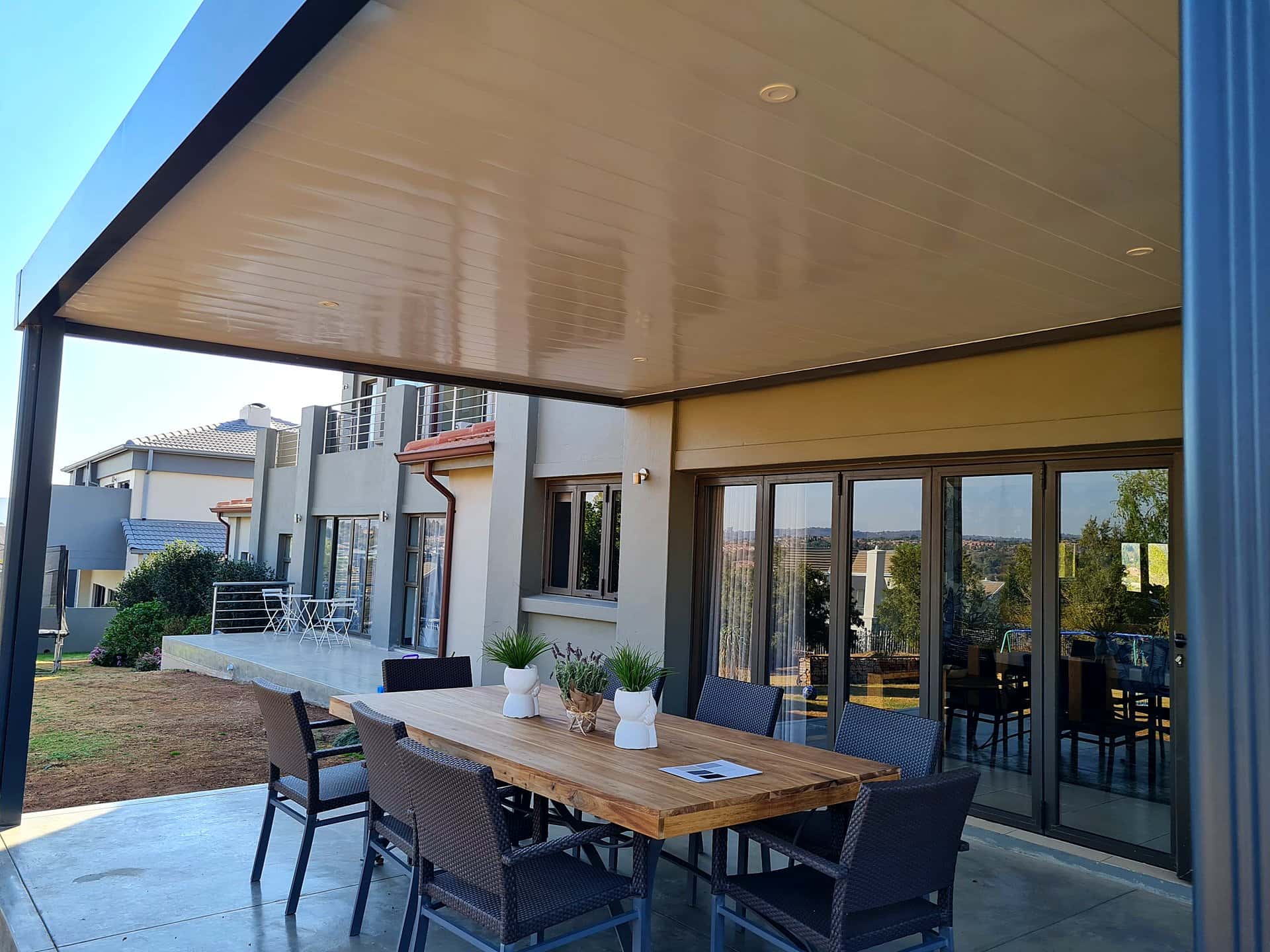 Outdoor dining area beneath a neatly panelled aluminium awning ceiling