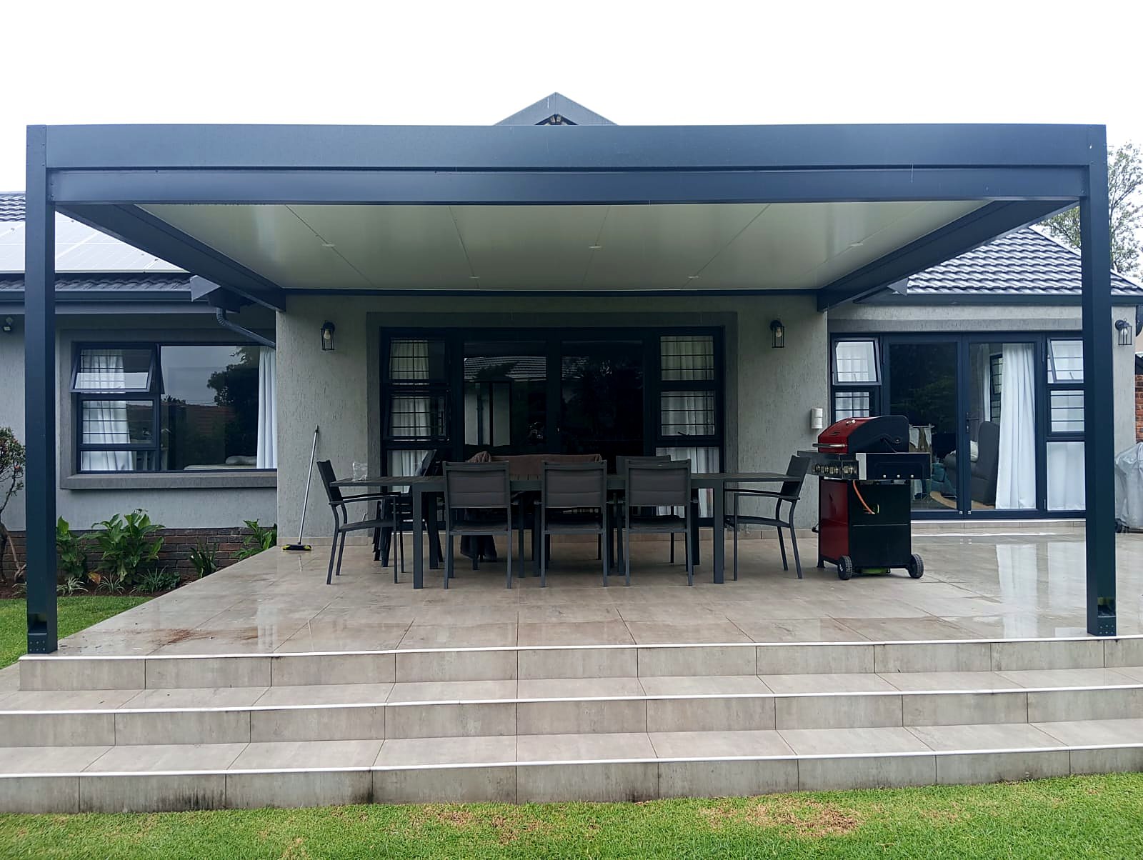 Symmetrical charcoal aluminium patio cover on the rear elevation of a Benoni home