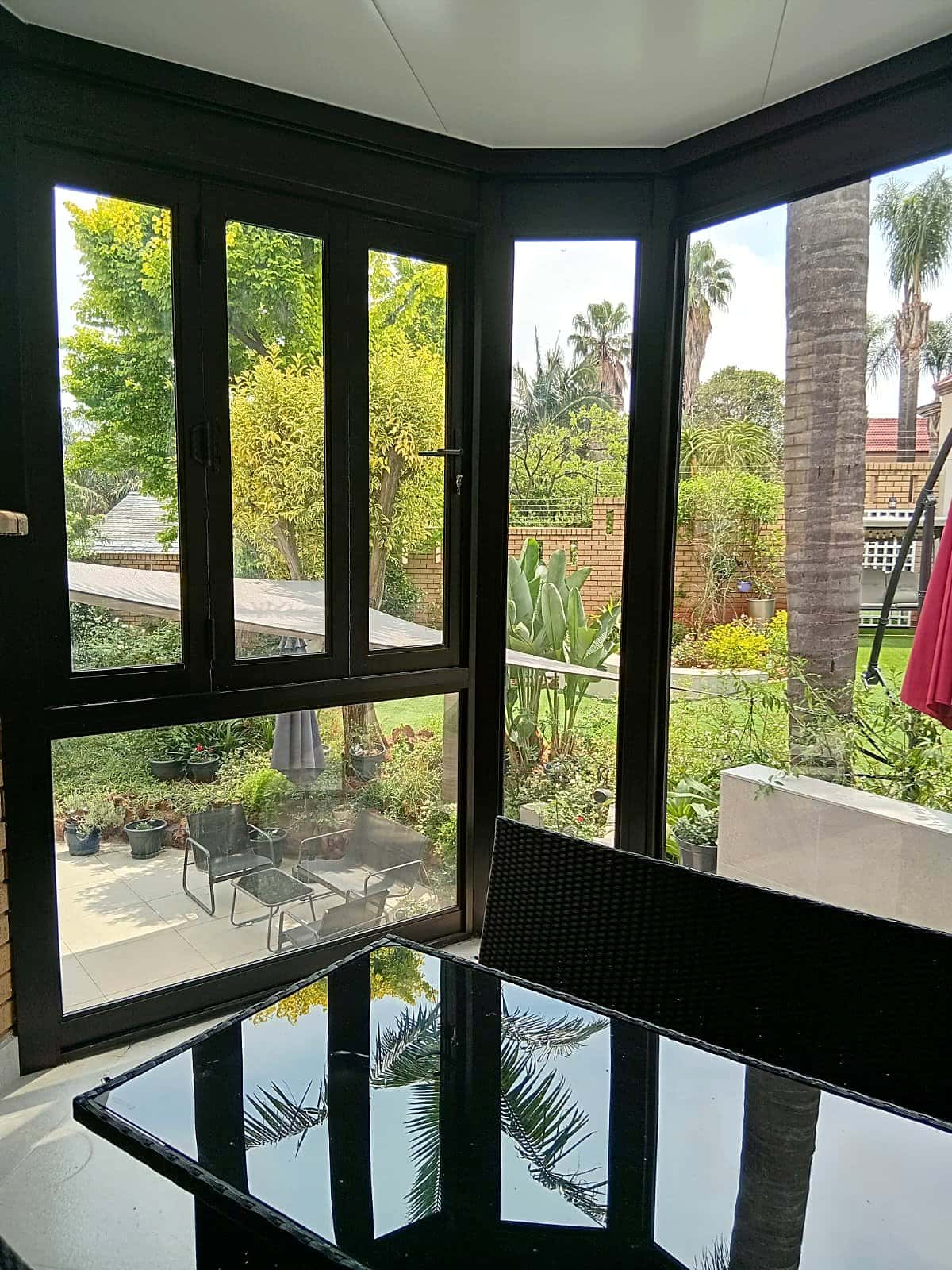 Aluminium patio ceiling with matching aluminium windows overlooking a garden