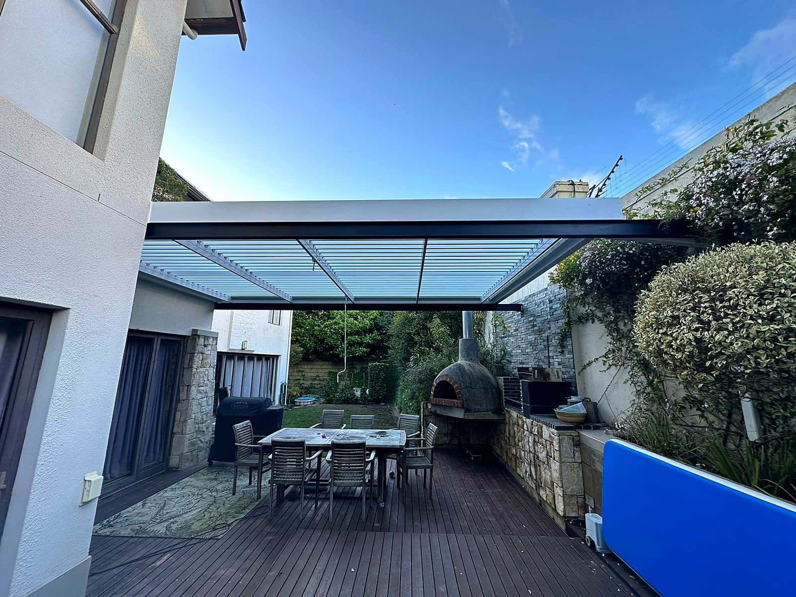Louvre roof pergola over an entertaining deck with a pizza oven