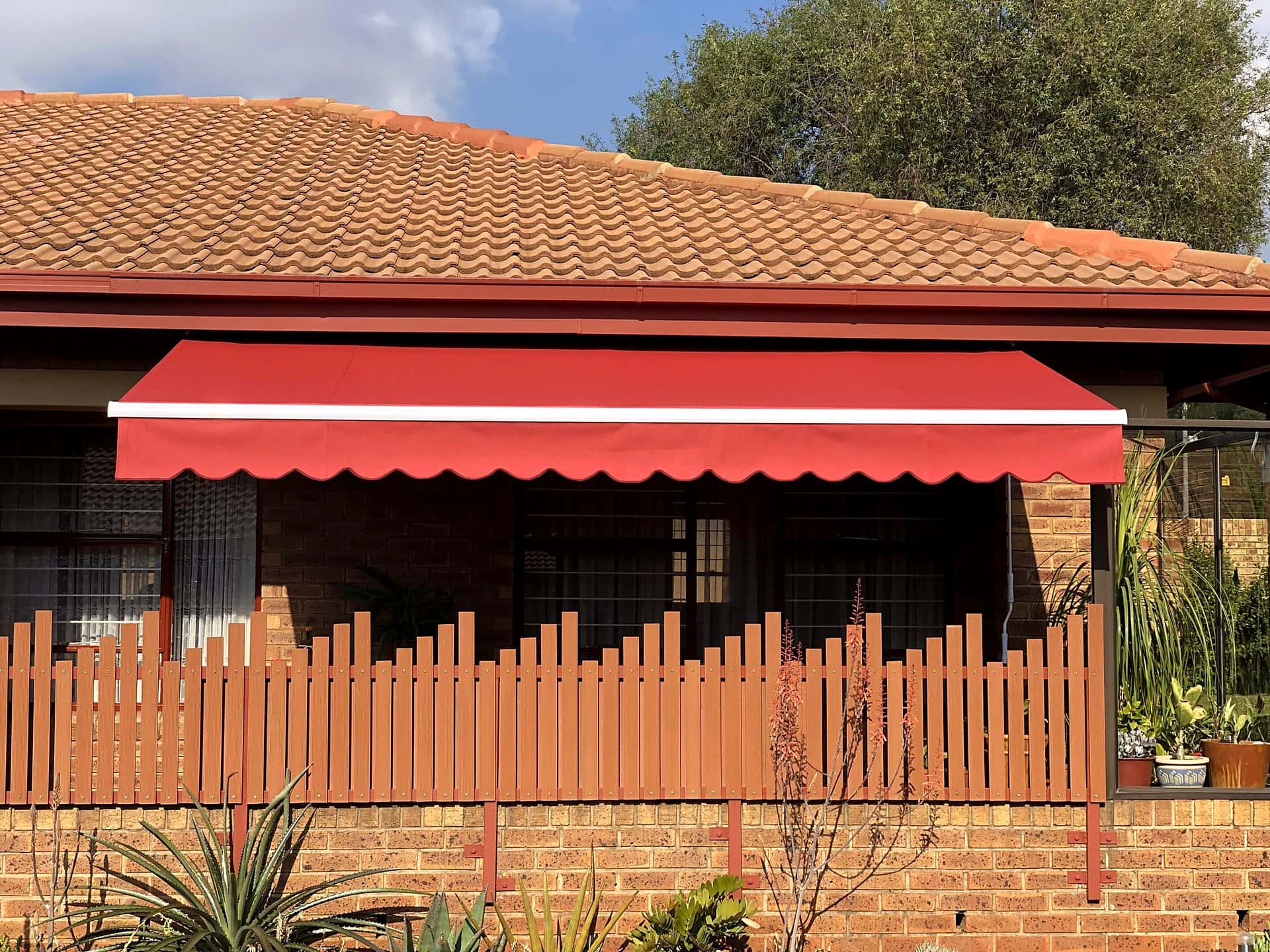 Bright red canvas fold-arm awning fully extended
