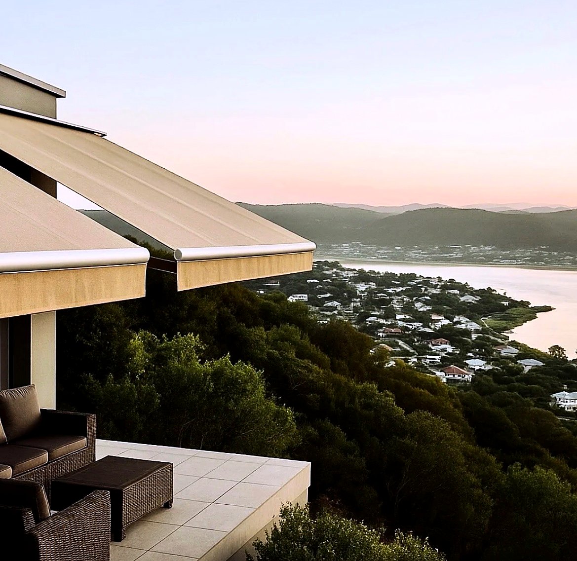 Fold-arm awnings on a balcony overlooking the Knysna lagoon at sunset