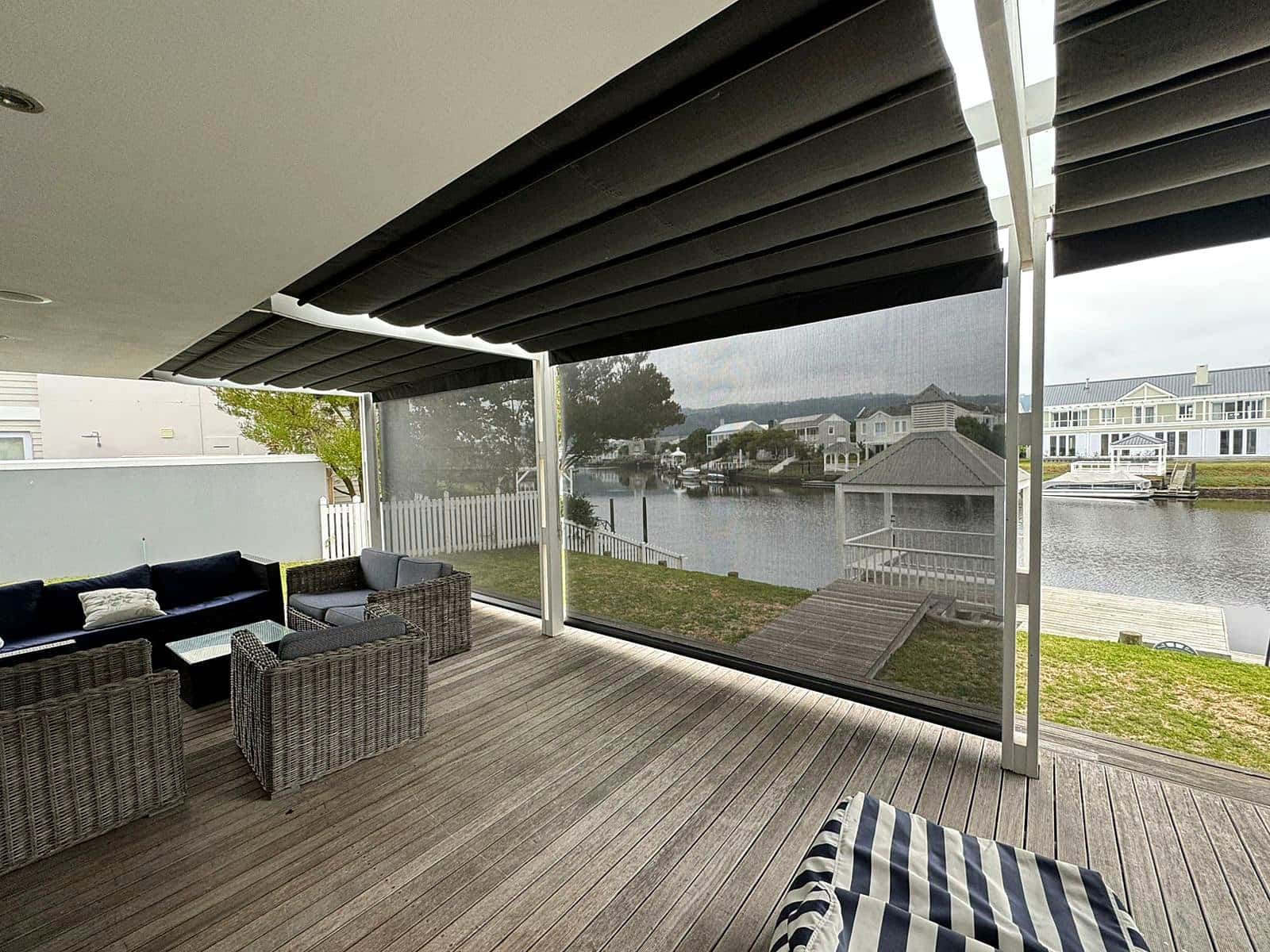 Retractable canopy awning with drop-down screens over a waterfront deck on Thesen Island