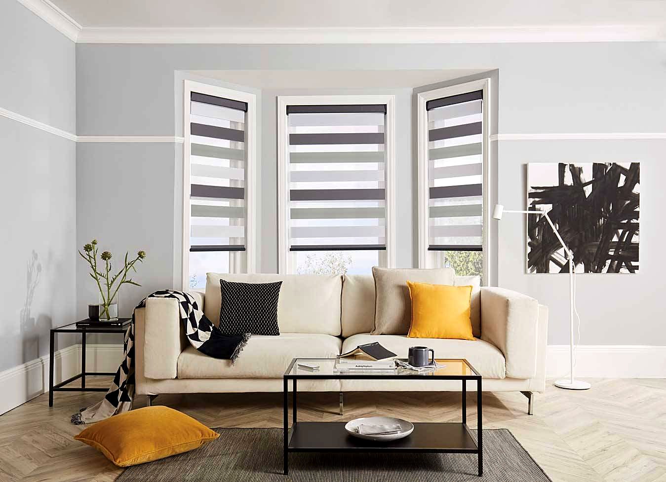Grey and white zebra roller blinds on a lounge bay window