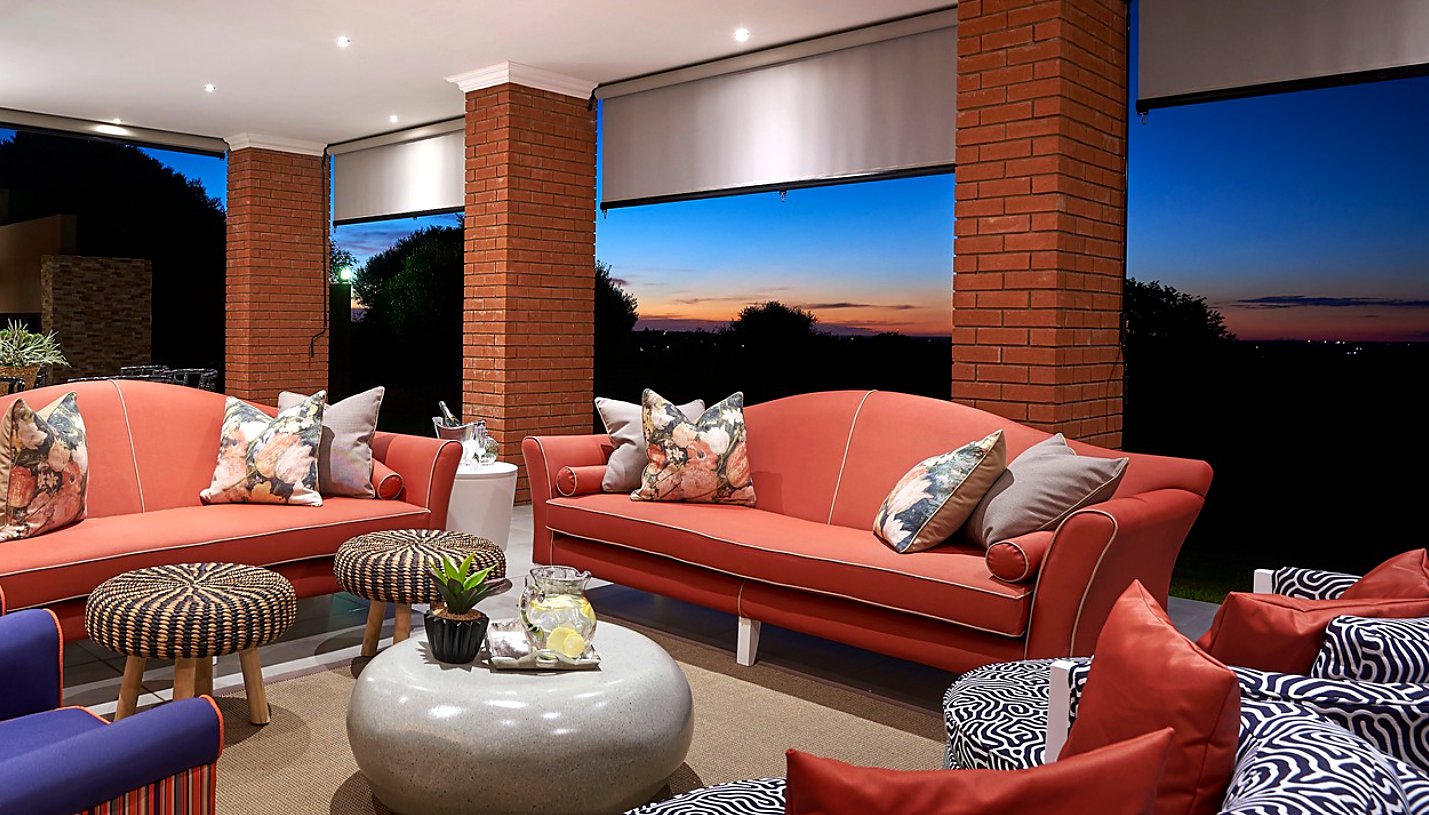 Outdoor roller blinds enclosing a South African patio at dusk