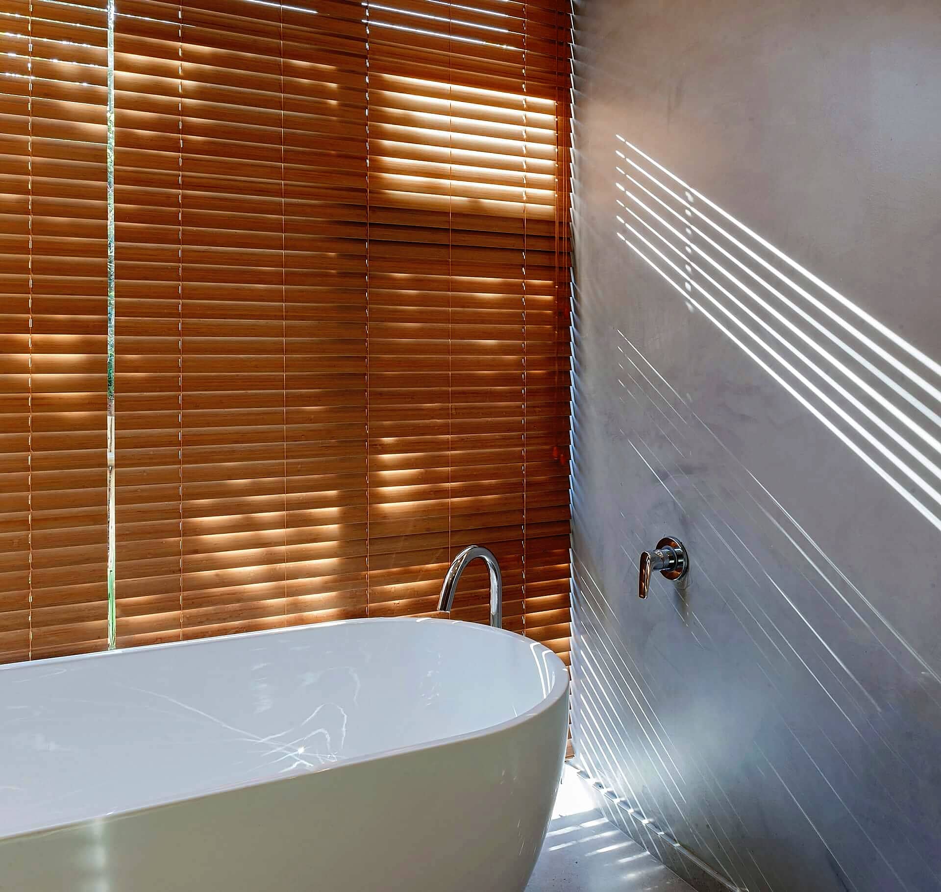 Sunlit bamboo venetian blind in a spa-style bathroom