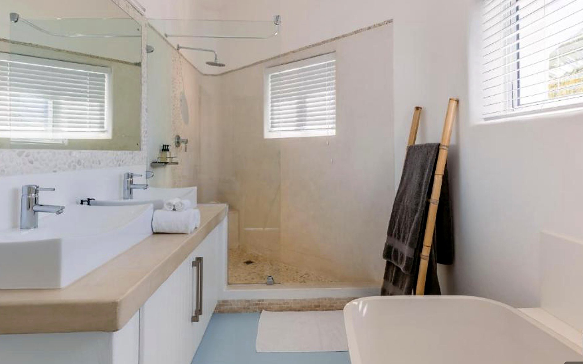White venetian blinds above a bath in a bright family bathroom